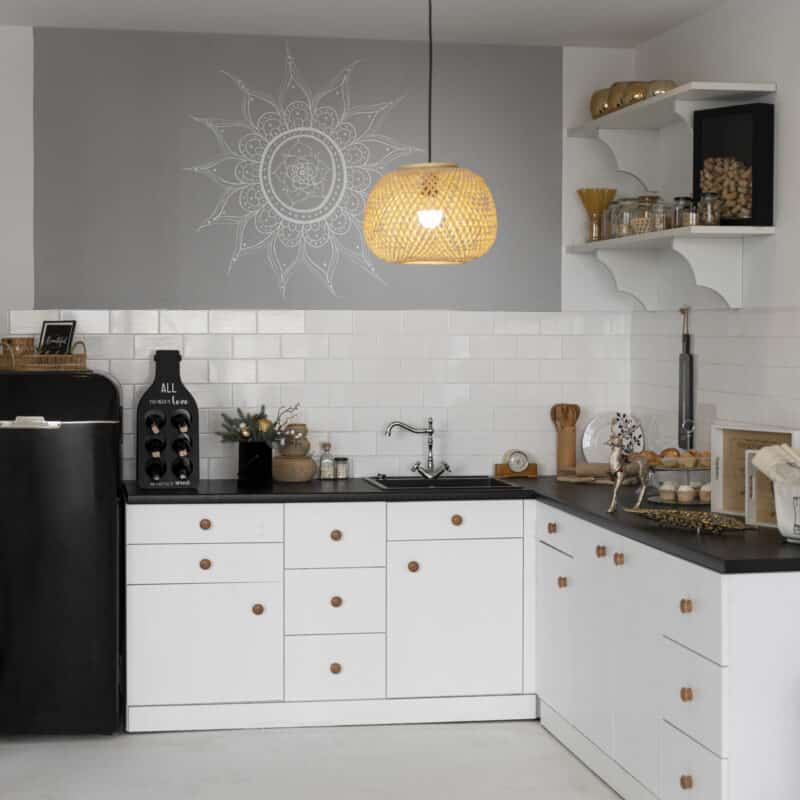 Modern custom kitchen with white cabinets, black countertop, wooden knobs, open shelving, built-in sink, and pendant light, showcasing efficient storage and minimalist design.